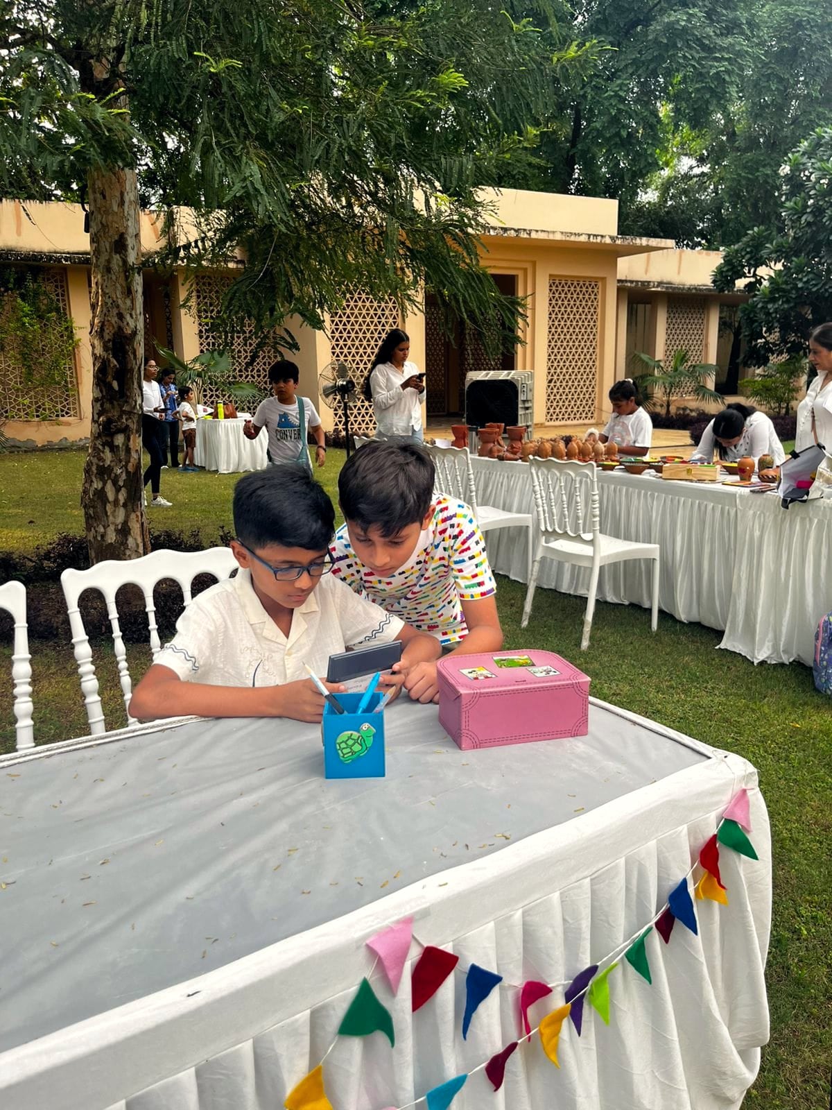 Children working on a craft project together at an outdoor Pineappletales workshop.